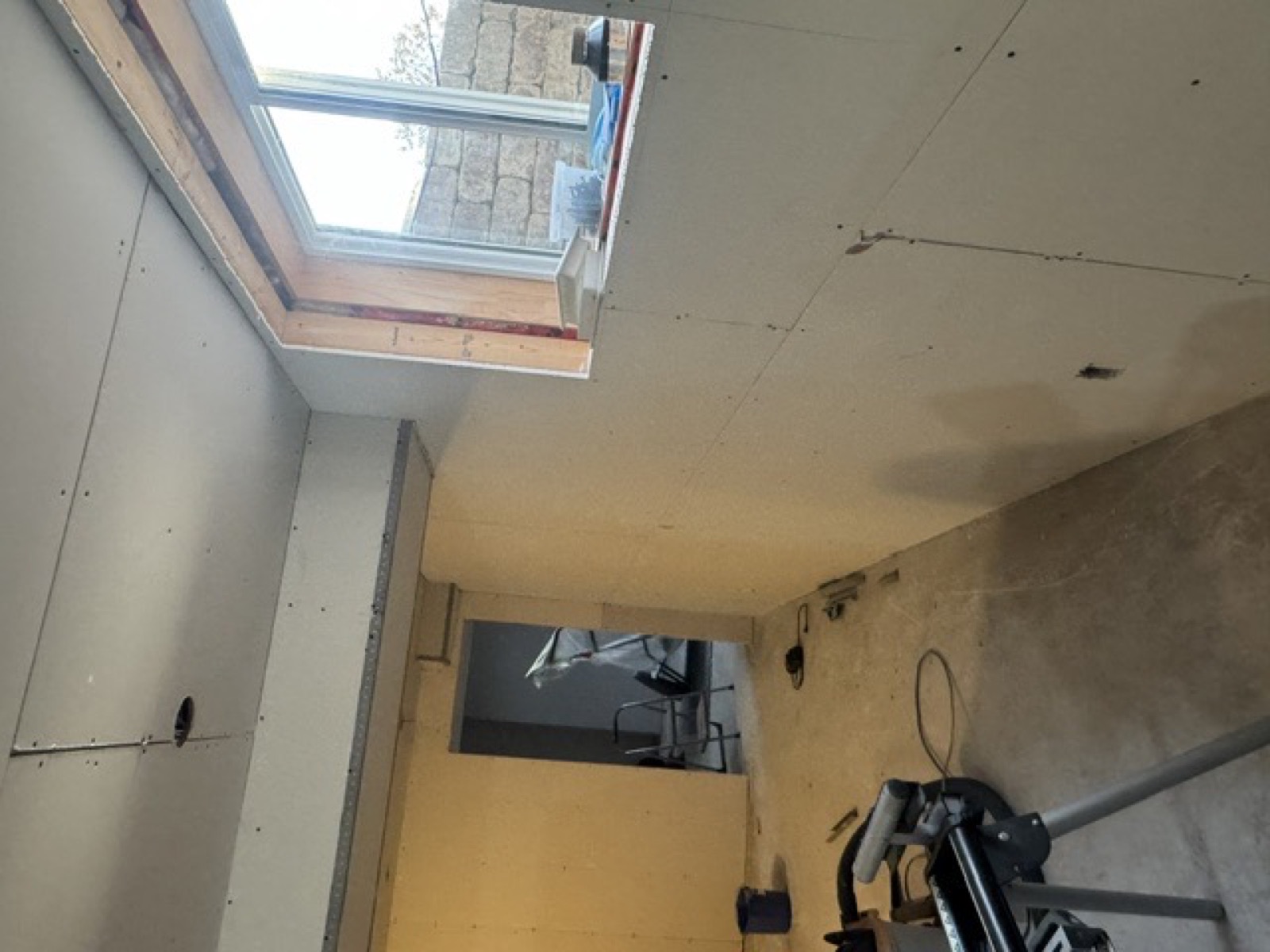 The same basement room with drywall boarded, joints not yet taped